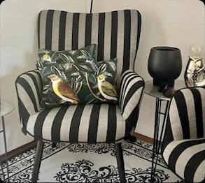 Gestreifter Sessel mit gemustertem Kissen im Atelier